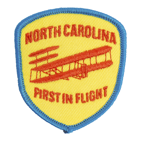 North Carolina patch, yellow background with blue border, First in Flight below plane